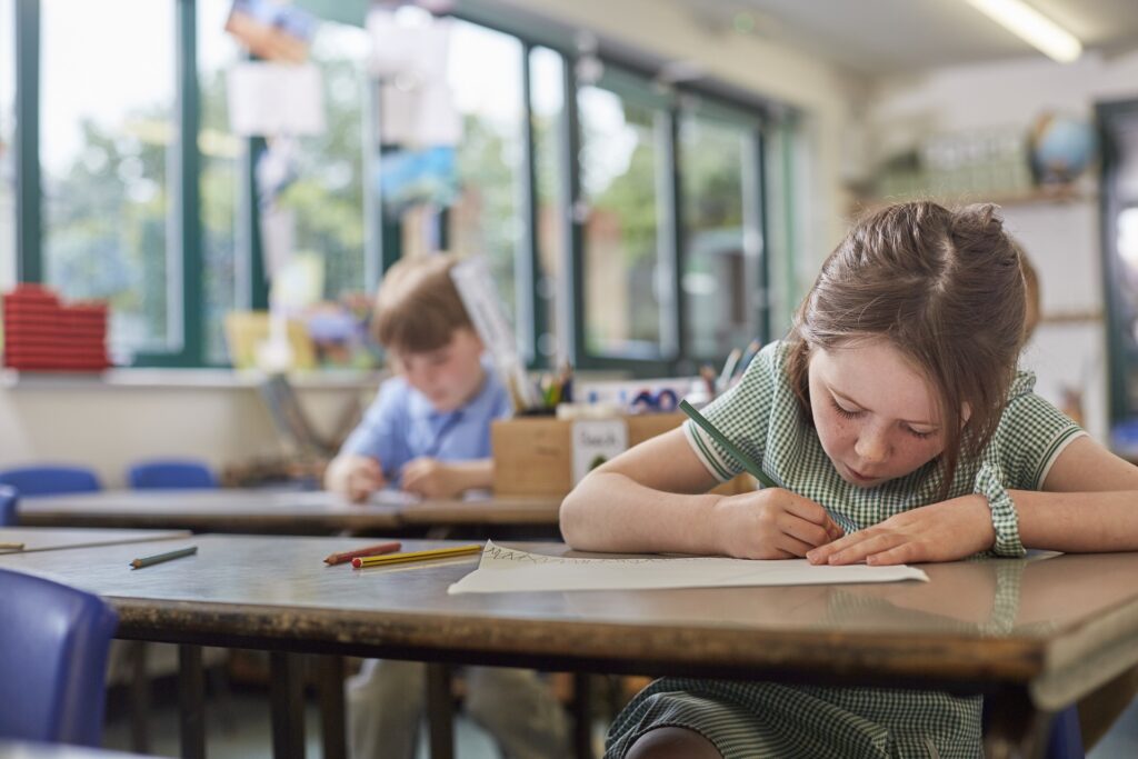 Écolière écrit dans la leçon de classe